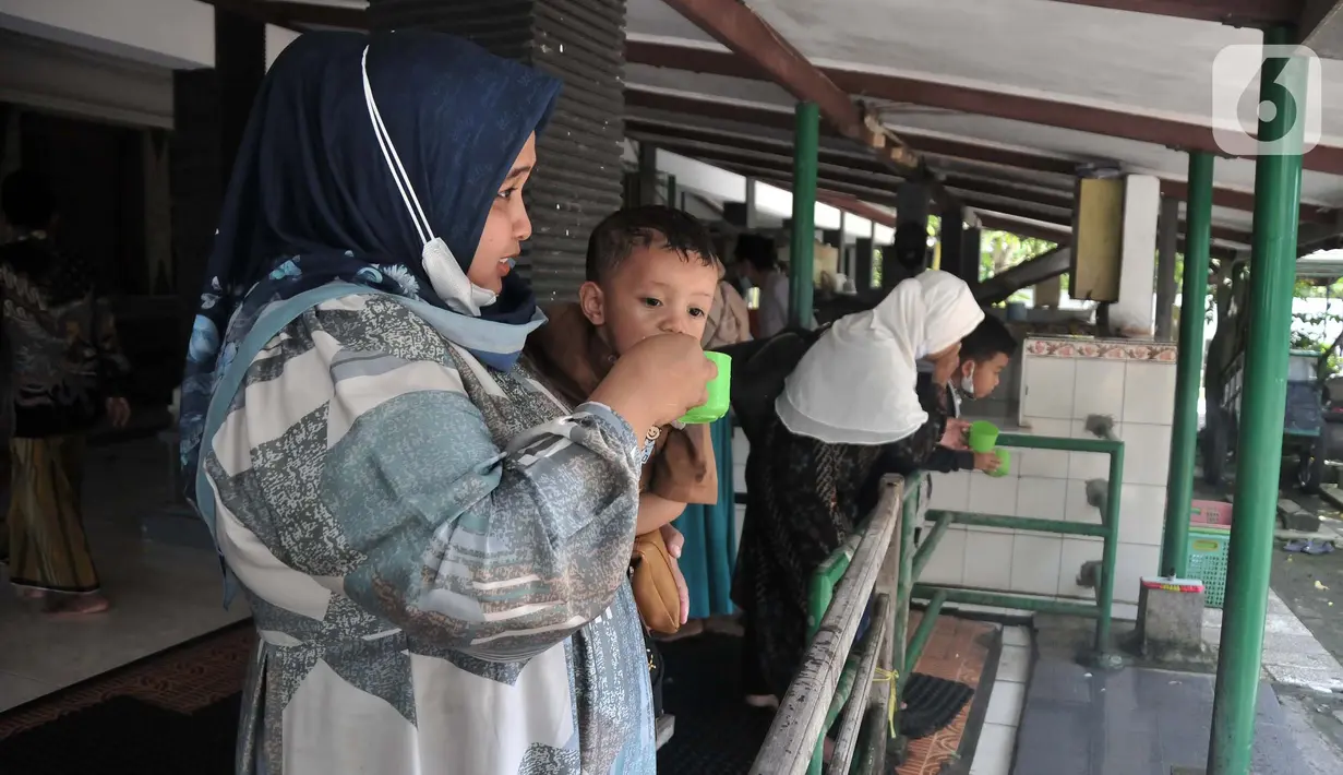 Peziarah saat meminum air dari gentong peninggalan Sunan Kalijaga di Desa Kadilangu, Demak, Jawa Tengah, Selasa (29/3/2022). Setelah sempat ditutup akibat pandemi Covid-19, makam salah satu Wali Songo tersebut ramai didatangi peziarah sebagai tradisi jelang Ramadhan. (merdeka.com/Iqbal S Nugroho)
