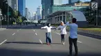 Dua orang wanita berfoto dengan latar belakang Jalan MH Thamrin yang masih ditutup oleh aparat keamanan di Jakarta, Jumat (24/5/2019). Ditutupnya Jalan MH Thamrin terkait unjuk rasa menolak hasil Pemilu 2019 dimanfaatkan sebagian warga untuk berfoto. (Liputan6.com/Immanuel Antonius)