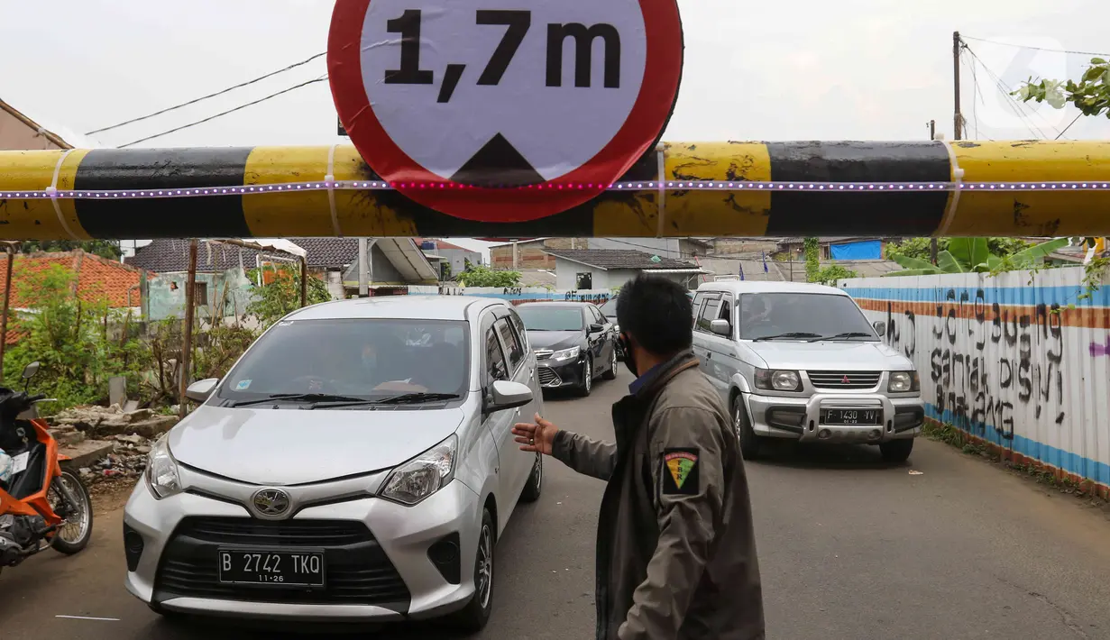 Warga mengatur lalu lintas kendaraan yang melintas di Jembatan Antelope, Curug, Bekasi, Jawa Barat, Selasa (14/6/2022). Jembatan Antelope tidak amblas melainkan adanya pemasangan girder proyek kereta cepat dan hanya dapat dilalui kendaraan dengan ketinggian maksimal 1,7 meter dari tanggal 13 Juni hingga 10 Agustus 2022. (Liputan6.com/Herman Zakharia)