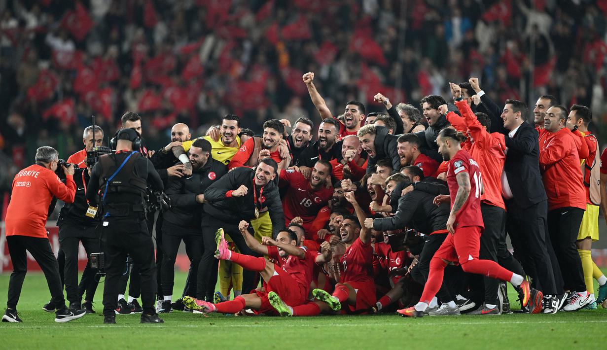 Sejumlah pemain, pelatih, dan ofisial Timnas Turki melakukan selebrasi setelah menang 4-0 atas Latvia pada laga Grup D Kualifikasi Euro 2024 di Konya Buyuksehir Belediye Stadium, Konya, Turki, Senin (16/10/2023) dini hari WIB. Kemenangan ini membuat Turki lolos ke putaran final Euro 2024. (AFP/Ozan Kose)