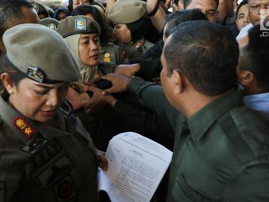 Ibu-ibu personel Satpol PP bersitegang dengan petugas keamanan di depan Hotel Alexis, Jakarta, Kamis (29/3). Pemprov DKI Jakarta resmi menutup operasi Hotel Alexis. (Liputan6.com/Immanuel Antonius)