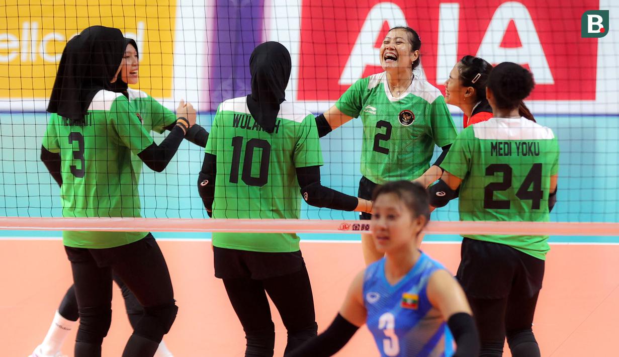 Pemain Timnas Bola Voli Putri Indonesia, Ratri Wulandari melakukan selebrasi bersama rekannya setelah mencetak poin pada laga lanjutan Grup A Bola Voli Putri SEA Games 2023 melawan Myanmar di Olympic Complex Indoor Stadium, Phnom Penh, Kamboja, Kamis (11/5/2023). Ratri berhasil mencetak total 19 poin, dimana sebanyak 13 angkanya ditorehkan melalui situasi bola servis. (Bola.com/Abdul Aziz)