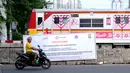 Warga melintas di depan spanduk sosialisasi penutupan perlintasan kereta di Jalan Angkasa, Jakarta, Minggu (15/10). Penutupan secara permanen perlintasan KA di Jalan Angkasa akan dilakukan pada 3 November mendatang. (Liputan6.com/Helmi Fithriansyah)