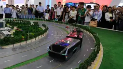 Pengunjung melihat sebuah model bus yang mengangkangi jalan di sebuah pameran di Beijing, Cina, (19/5). Bus ini bergerak menggunakan listrik, lebih hemat energi karena membawa 1.200 orang setara 40 bus konvensional. (REUTERS/Hu Qingming)