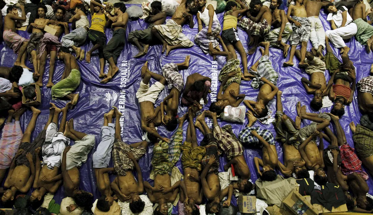 Dengan beralaskan terpal para pengungsi tidur di tempat penampungan, Lhoksukon, Aceh, Senin (11/5/2015). Sekitar 500 migran terdampar di pantai Aceh setelah terapung-apung di laut selama sebulan karena kehabisan bahan bakar. (REUTERS/Roni Bintang)