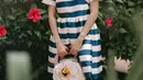 Penampilan memesona Azizah Salsha pakai dress bercorak garis-garis biru dan putih dengan detail corak bunga merah di salah satu sisi dadanya. [Foto: Instagram/azizahsalsha_]