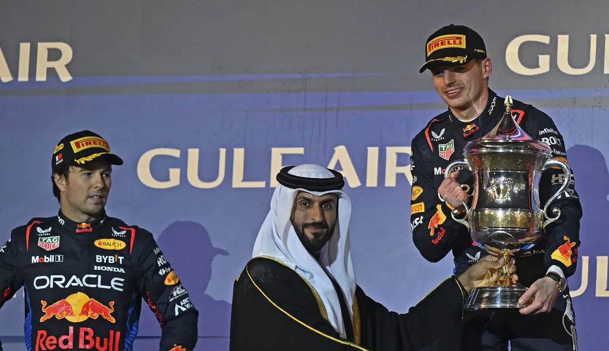 Pembalap Red Bull Racing, Max Verstappen (kanan) menerima trofi saat memenangkan Formula 1 GP Bahrain 2024 yang berlangsung di Sirkuit Sakhir, Bahrain, Sabtu (03/03/2024) malam WIB. (AFP/Andrej Isakovic)
