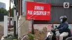 Pengguna jalan melintas di depan poster protes warga terhadap pembangunan flyover di kawasan Tanjung Barat, Jakarta, Rabu (15/7/2020). Dalam poster protes tersebut, warga menuntut agar pembayaran pelunasan pembebasan lahan segera diselesaikan secara serentak. (Liputan6.com/Immanuel Antonius)