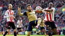 Striker Arsenal, Olivier Giroud (tengah), berebut bola dengan pemain Sunderland, Lamine Kone, dalam laga Liga Inggris di Stadium of Light, Sunderland, Minggu (24/4/2016) malam WIB. (AFP/Graham Stuart)