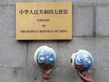 Massa Aliansi Mahasiswa Islam (AMI) menunjukkan simbol-simbol saat menggelar aksi di depan Kedutaan Besar China, Jakarta, Jumat (14/1/2022). Massa meminta pemerintah Indonesia untuk berbicara menentang genosida yang terjadi pada muslim Uighur di Xinjiang. (Liputan6.com/Faizal Fanani)