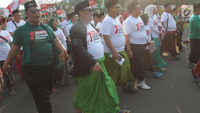 Para santri mengikuti jalan sehat sarungan di kawasan Monas, Jakarta, Minggu (30/9). Jalan sehat tersebut dilakukan dalam rangka memperingati Hari Santri yang jatuh pada 22Oktober mendatang. (Liputan6.com/Angga Yuniar)