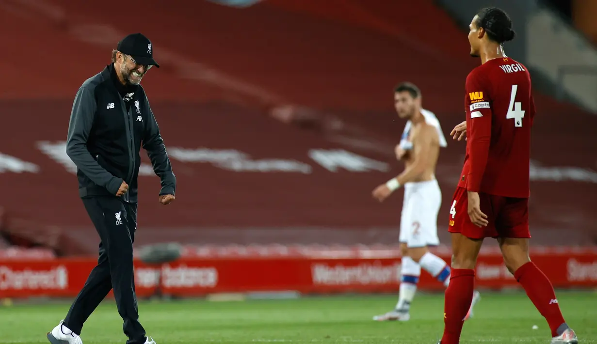 Pelatih Liverpool, Jurgen Klopp merayakan kemenangan dengan bek Virgil van Dijk setelah pertandingan melawan Crystal Palace pada lanjutan Liga Inggris di di Stadion Anfield di Liverpool, Inggris (24/6/2020). Liverpool menang telak 4-0 atas Crystal Palace. (Phil Noble/Pool via AP)
