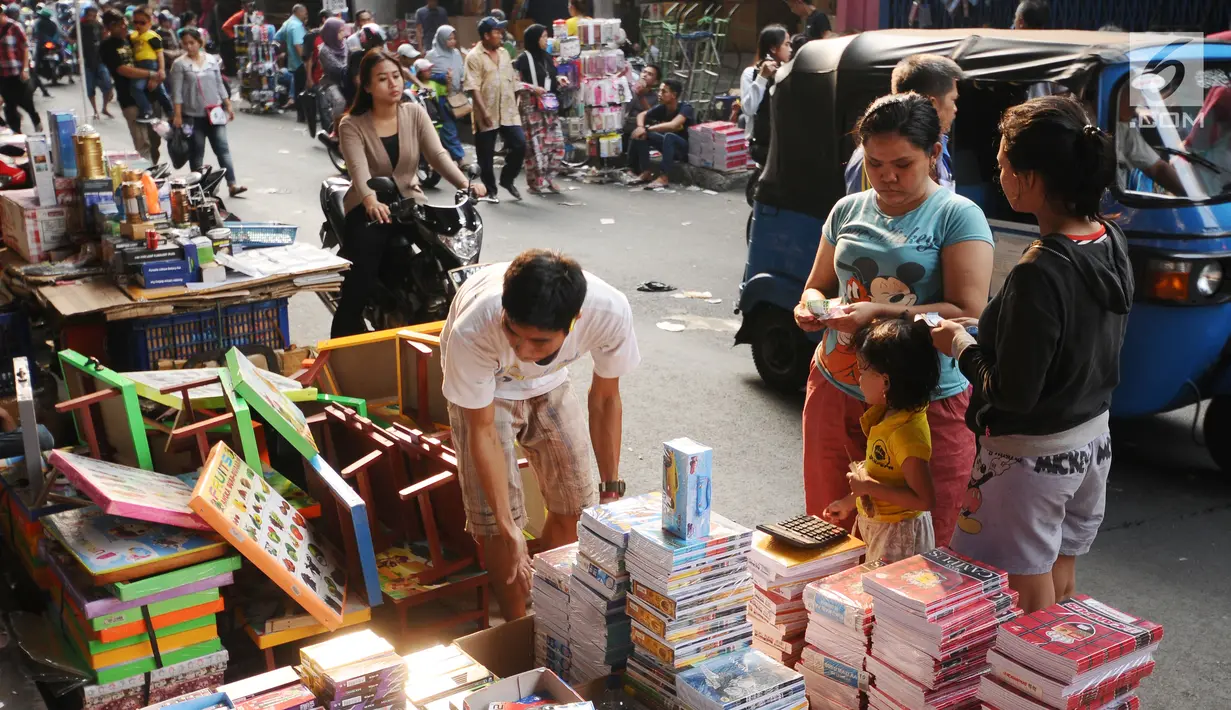 Warga memilih buku tulis ang dijajakan pedagang di sekitar Pasar Asemka, Jakarta, Rabu (5/7). Jelang bergantinya tahun ajaran baru, sejumlah warga berburu peralatan sekolah di kawasan Pasar Asemka Jakarta. (Liputan6.com/Helmi Fithriansyah)