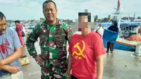 Emak-emak berbaju palu arit diamankan anggota TNI di tempat pelelangan ikan. (Liputan6.com/Fauzan)