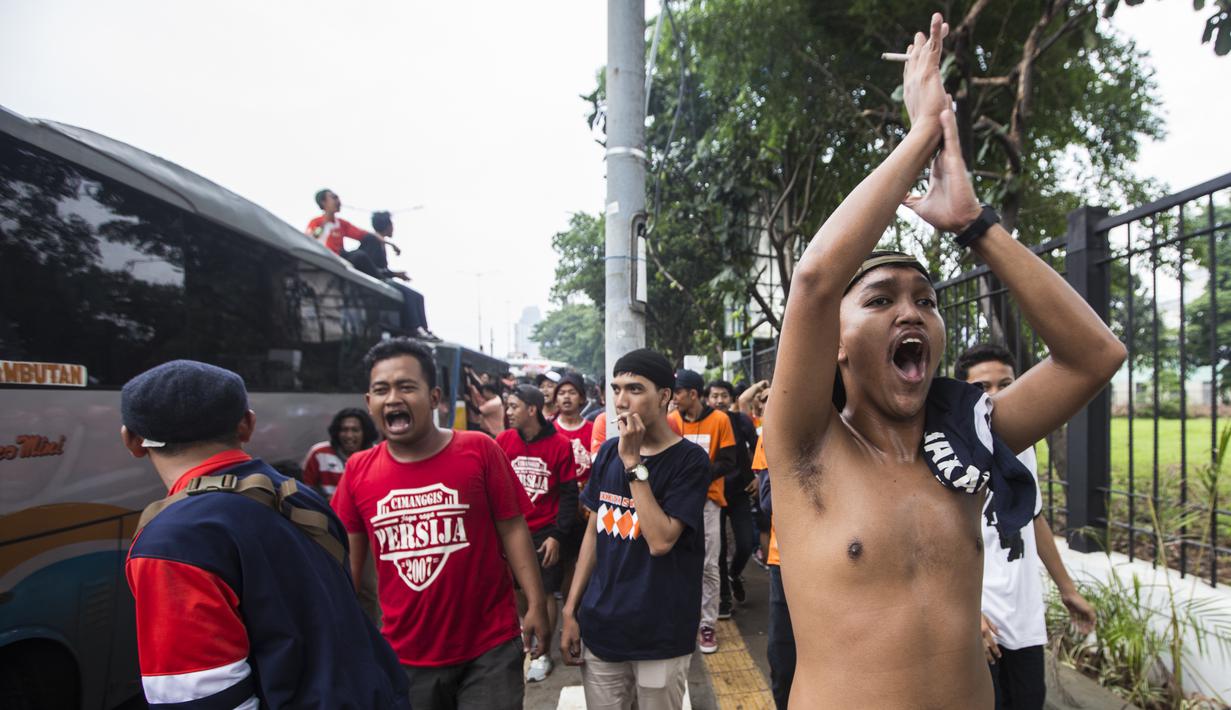 Suporter Persija Jakarta, The Jakmania, bernyanyi saat akan menonton laga Liga 1 melawan Mitra Kukar di Senayan, Jakarta, Minggu (9/12). Persija berpeluang besar menjadi juara jika berhasil menang. (Bola.com/Vitalis Yogi Trisna)