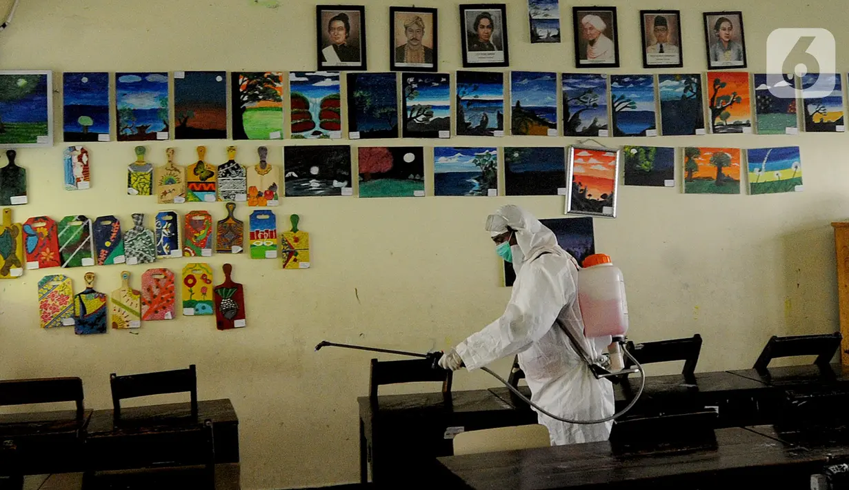 Petugas Palang Merah Indonesia (PMI) melakukan penyemprotan disinfektan di SMPN 216 Jakarta, Senin (16/3/2020). Mulai hari ini, aktivitas sekolah di sejumlah wilayah Indonesia diliburkan untuk mengantisipasi penyebaran virus corona COVID-19. (merdeka.com/Arie Basuki)