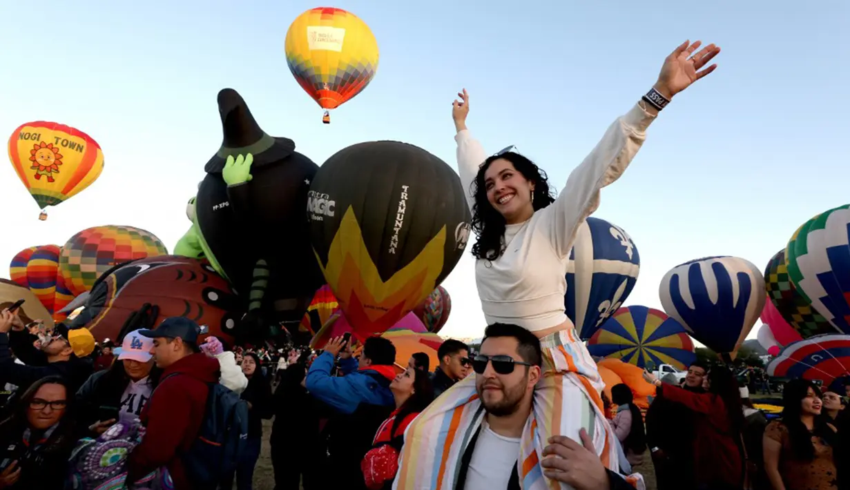 Sekelompok orang menyaksikan pengangkatan balon udara pada hari ketiga Festival Balon Udara Internasional ke-21 di Leon, negara bagian Guanajuato, Meksiko, 19 November 2023. (ULISES RUIZ/AFP)