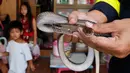 Petugas pemadam kebakaran Phinyo Pukphinyo menangkap ular di rumah warga di Bangkok, Thailand (6/11). Jumlah ular yang tertangkap dirumah warga meningkat 30 persen pada pertengahan 2017 dibandingkan 2016 dengan 29.000 kasus. (AP Photo/Sakchai Lalit)