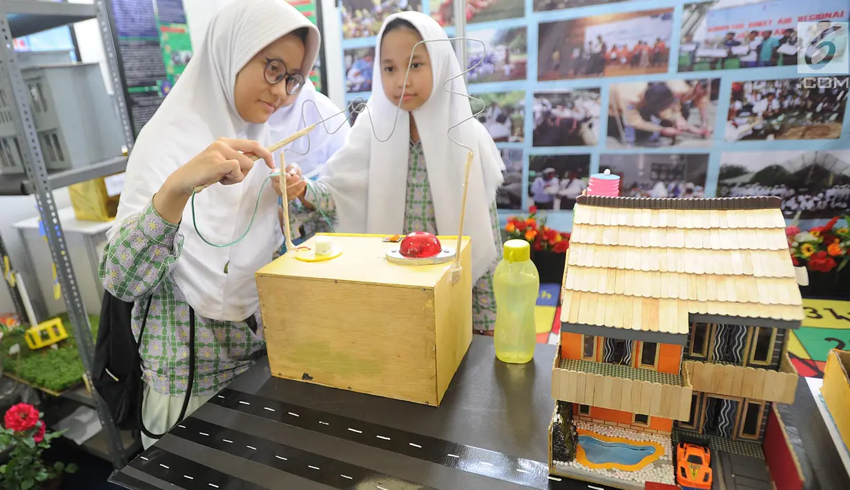 Dua murid SMP mencoba cara kerja dinamo listrik saat kegiatan Puspiptek Innovation Festival (PIF) 2018 di kawasan Puspiptek, Setu, Tangerang Selatan, kamis (27/9). PIF 2018 berlangsung hingga 30 September. (Merdeka.com/Arie Basuki)