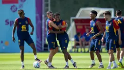 Pemain Spanyol Ansu Fati (tengah) dipeluk oleh Yeremy Pino (tengah kiri) saat berlatih bersama rekan setim mereka di Universitas Qatar, Doha, Qatar, Selasa (29/11/2022). Spanyol akan melawan Jepang dalam pertandingan Grup E Piala Dunia 2022 pada 1 Desember mendatang. (AP Photo/Julio Cortez)