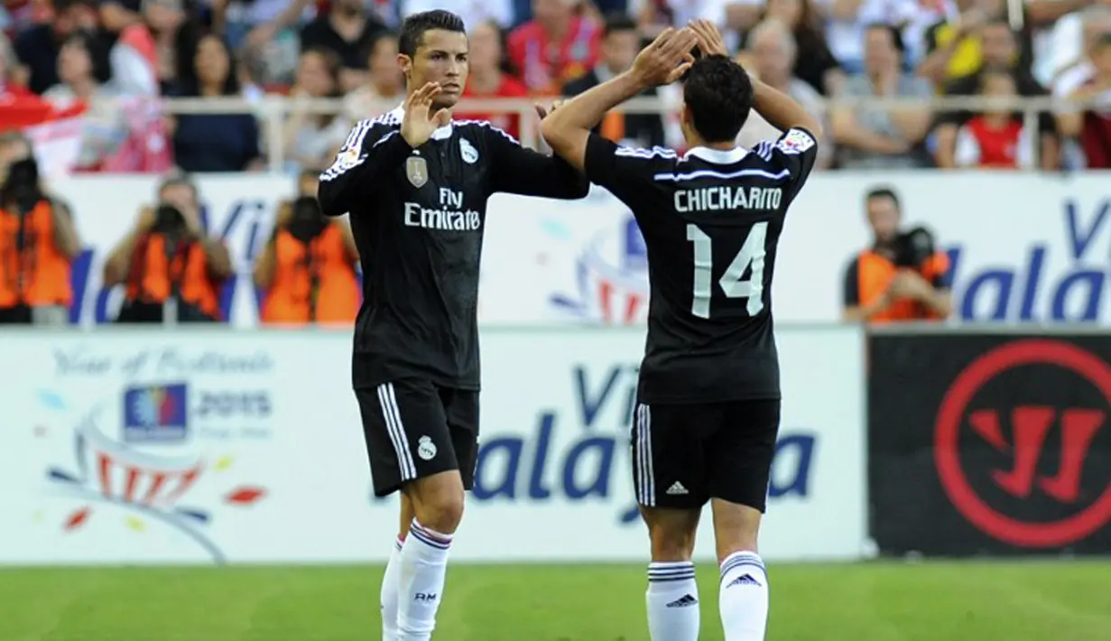 Gelandang Real Madrid, Cristiano Ronaldo (kiri) merayakan selebrasi bersama penyerang Chicharito  usai mencetak gol saat Laga Liga Spanyol di Estadio Ramon Sanchez Pizjuan, (2/5/2015). Real Madrid menang 3-2 atas Sevilla. (AFP PHOTO/ Gogo Lobato)