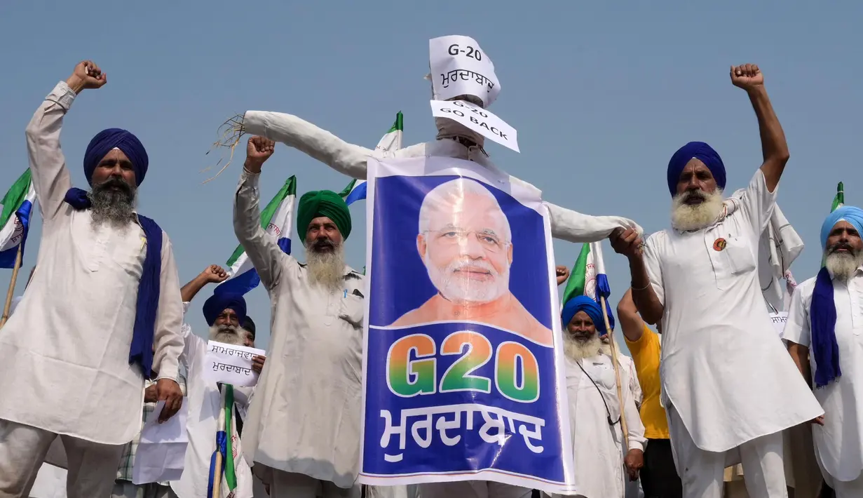 Sejumlah petani membentangkan poster bergambar Perdana Menteri India Narendra Modi dengan logo KTT G20 India selama protes di Amritsar pada tanggal 8 September 2023. (Narinder NANU/AFP)