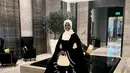 Halima Aden kembali tampil dengan outfit unik. Atasan hitam dengan detail lengan super lebar dan flowy ke bawah, dipadunya juga dengan celana panjang hitam. [Foto: Instagram/halima]