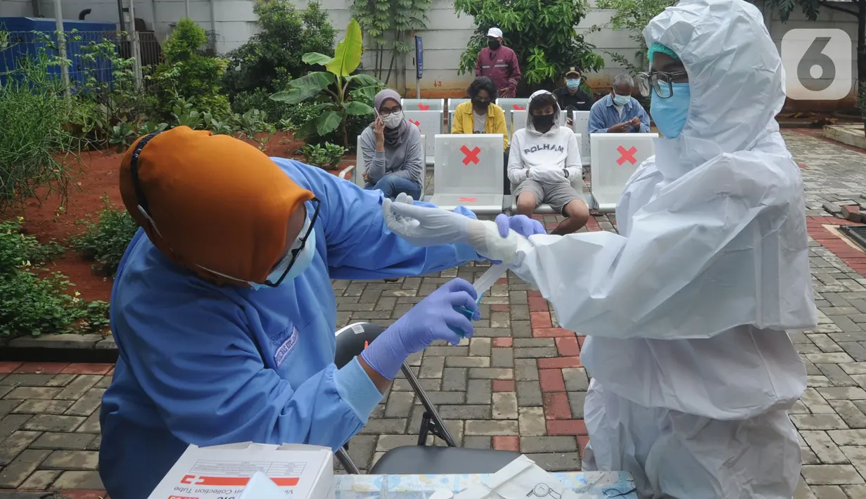 Tenaga kesehatan melakukan persiapan sebelum kegiatan tes swab massal di Puskesmas Ciganjur, Jakarta, Kamis (7/1/2020). Lonjakan kasus virus corona berpotensi terjadinya krisis tenaga kesehatan (nakes) karena banyak yang tertular dan gugur saat menangani pasien Covid-19. (merdeka.com/Arie Basuki)
