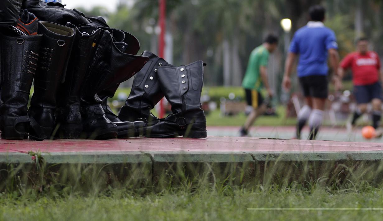 Sepatu Petugas Dishub ditaruh saat olahraga sepak bola di Kawasan Monumen Nasional, Jakarta, Rabu (13/2). Monas merupakan salah satu lokasi yang kerap dijadikan ruang olahraga bagi warga ibukota. (Bola.com/M. Iqbal Ichsan)