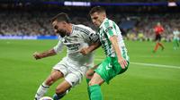 Bek Real Madrid asal Spanyol, Dani Carvajal, berebut bola dengan bek Real Betis asal Prancis, Romain Perraud, selama pertandingan sepak bola liga Spanyol antara Real Madrid CF dan Real Betis di stadion Santiago Bernabeu, Madrid, pada 1 September 2024.Thomas COEX / AFP