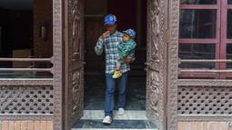 Dor Bahadur Khapangi digendong oleh seorang anggota keluarga saat tiba untuk acara penyerahan sertifikat Rekor Dunia Guinness di Kathmandu, Nepal, Selasa (24/5/2022). Khapangi yang memiliki tinggi 2 kaki 4,9 inci (73,43 meter), dinobatkan sebagai remaja terpendek di dunia oleh Guinness World Records. (AP Photo/Niranjan Shrestha)