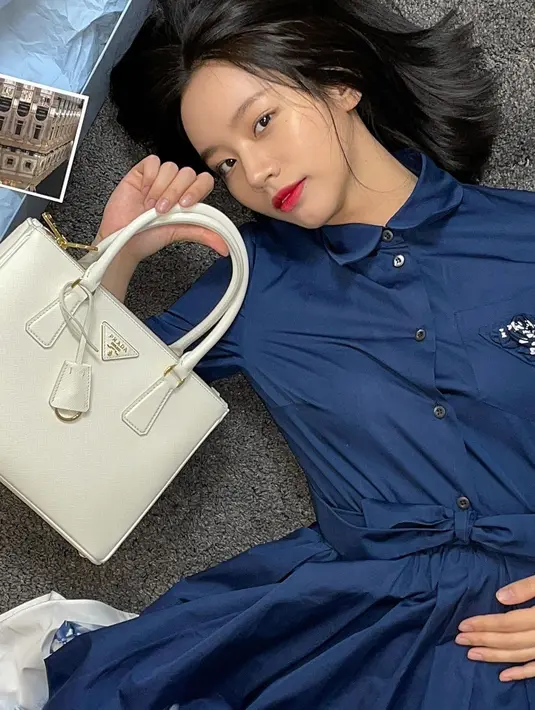 Pemeran drama Reply 1988 menampilkan OOTD yang menarik dengan perpaduan warna navy. Ia mengenakan shirtdress dari Prada dengan detail ruffle di bagian bawah. Tampilan yang clean pada outfit Hyeri dipadukan dengan tas putih dari Prada. (instagram/hyeri_0609)