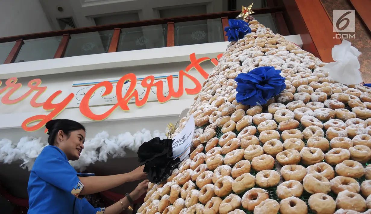 Karyawan menghiasi pohon Natal yang terbuat dari susunan donat di lobby hotel Dafam Semarang, Rabu (12/12). Pohon Natal setinggi 3 meter untuk menyambut Natal tersebut terdapat 2000 buah kue donat. (Liputan6.com/Gholib)