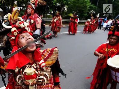 Peserta atraksi Tatung mengiris lidahnya dengan pedang saat arak-arakan perayaan Cap Go Meh di kawasan Petojo, Jakarta, Selasa (19/2). Arak-arakan ini melewati kawasan Petojo hingga Cideng. (Liputan6.com/Angga Yuniar)