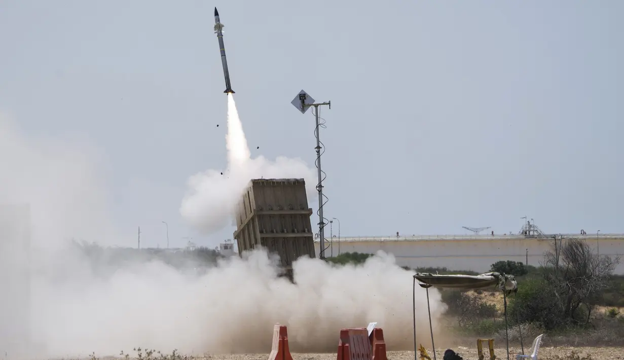 Seorang tentara Israel berlindung saat sistem pertahanan udara Iron Dome diluncurkan untuk mencegat roket yang ditembakkan dari Jalur Gaza di Ashkelon, Israel, 7 Agustus 2022. Israel telah membunuh dua militan senior Jihad Islam dalam tiga hari serangan di Jalur Gaza. (AP Photo/Ariel Schalit)