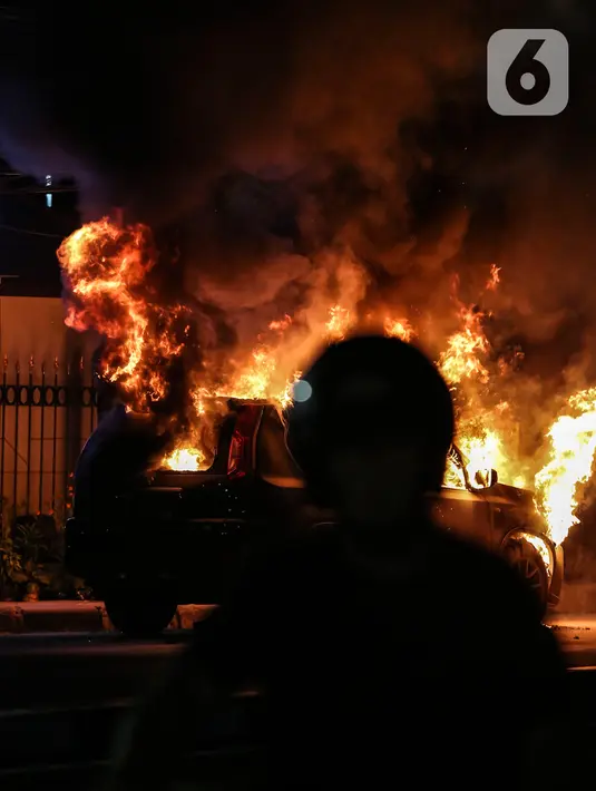 Kobaran api melahap sebuah mobil di Jalan Asia Afrika, Jakarta, Kamis (18/3/2021) dinihari. Diduga penyebab api adalah akibat dari hubungan pendek arus listrik yang terjadi di bagian mesin. (Liputan6.com/Johan Tallo)
