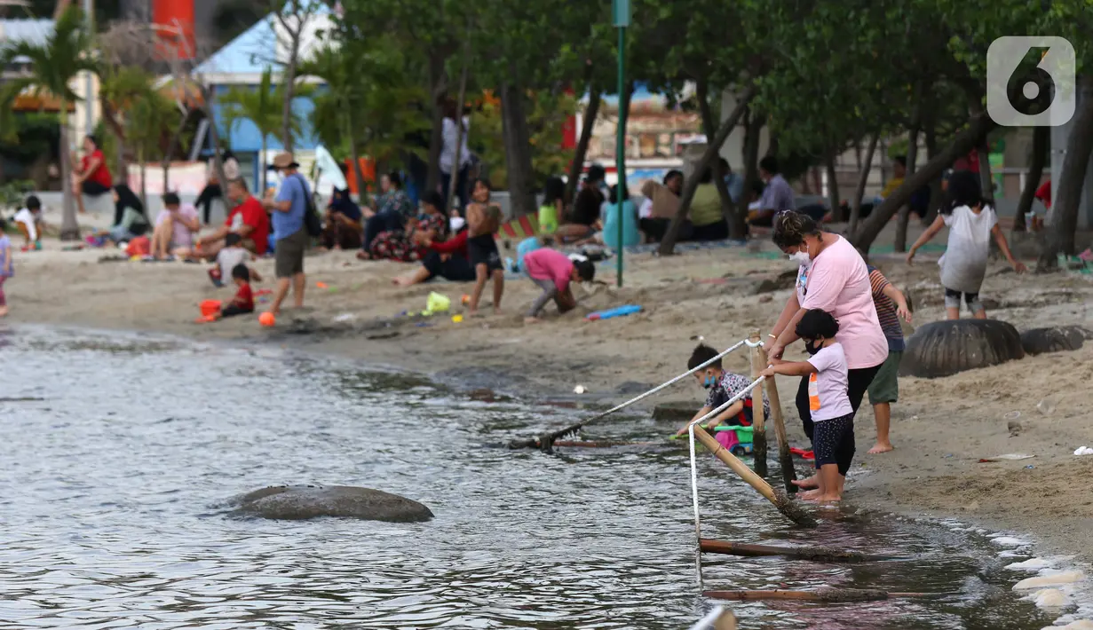 Pengunjung bersama anak-anak menikmati suasana Pantai Indah Taman Impian Jaya Ancol, Jakarta, Kamis (29/10/2020). Libur panjang di masa pemberlakuan PSBB transisi Jakarta dimanfaatkan warga untuk mengunjungi lokasi-lokasi wiisata. (Liputan6.com/Helmi Fithriansyah)