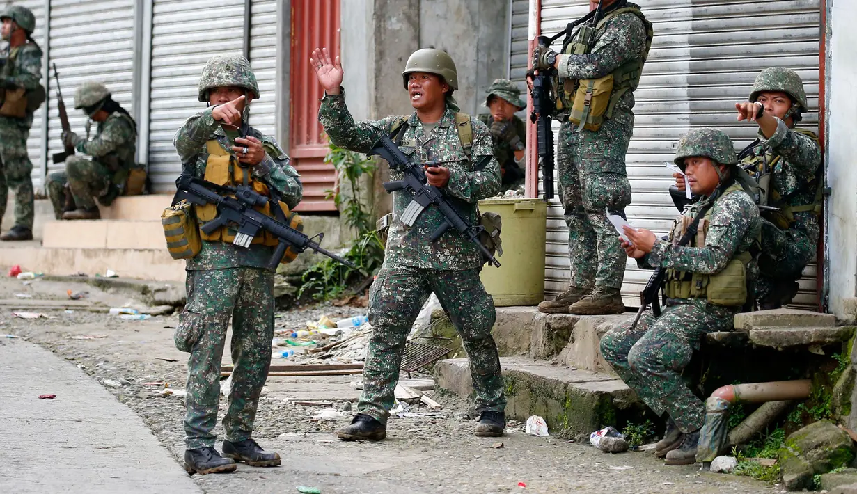 Sejumlah tentara pemerintah mengambil posisi saat memerangi kelompok Maute di Kota Marawi, Filipina, (28/5). Sekitar 61 militan, 20 anggota pasukan keamanan dan 19 warga sipil terbunuh akibat pertempuran tersebut. (AP Photo/Bullit Marquez)