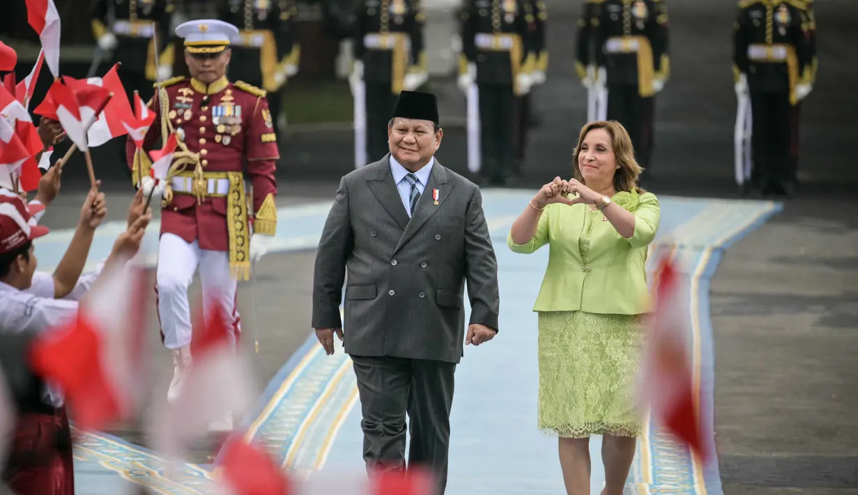 Presiden Republik Indonesia Prabowo Subianto (kiri) bersam Presiden Peru Dina Boluarte menyaksikan anak-anak mengibarkan bendera kedua negara sebelum pertemuan mereka di Istana Merdeka, Jakarta, pada 11 Agustus 2025. (Bay ISMOYO/AFP)