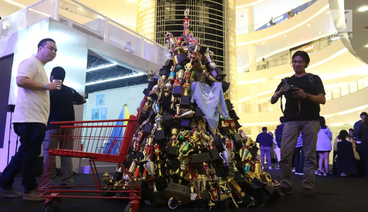 Sebuah instalasi dari tumpukan piala yang dipamerkan dalam Adidas Original Is Never Finished di Senayan City, Jakarta, Rabu (28/2). (Liputan6.com/Angga Yuniar)