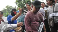 Tersangka JL melakukan reka ulang saat hendak membunuh aktivis Jopi Peranginangin, Kemang, Jakarta, Kamis (11/06/2015). Proses rekonstruksi tersebut terdiri dari 31 reka adegan yang diperankan oleh tersangka dan saksi-saksi. (Liputan6.com/Andrian M Tunay)