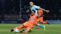 Bek Persija Jakarta, Maman Abdurrahman (jingga), berupaya menyapu bola agar tidak diraih oleh pemain Persela Lamongan, Rafinha, dalam laga pekan kelima Shopee Liga 1 2019 di Stadion Surajaya, Lamongan, Sabtu (22/6/2019). (Bola.com/Aditya Wany)