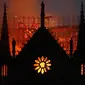 Api dan asap mengepul dari kebakaran Gereja Katedral Notre-Dame di pusat kota Paris, Prancis, pada Senin (15/4) waktu setempat. Api dengan cepat melalap bagian atap gereja yang dibangun pada abad ke-12 itu dan merupakan salah satu ikon wisata di Paris. (AP Photo/Thibault Camus)