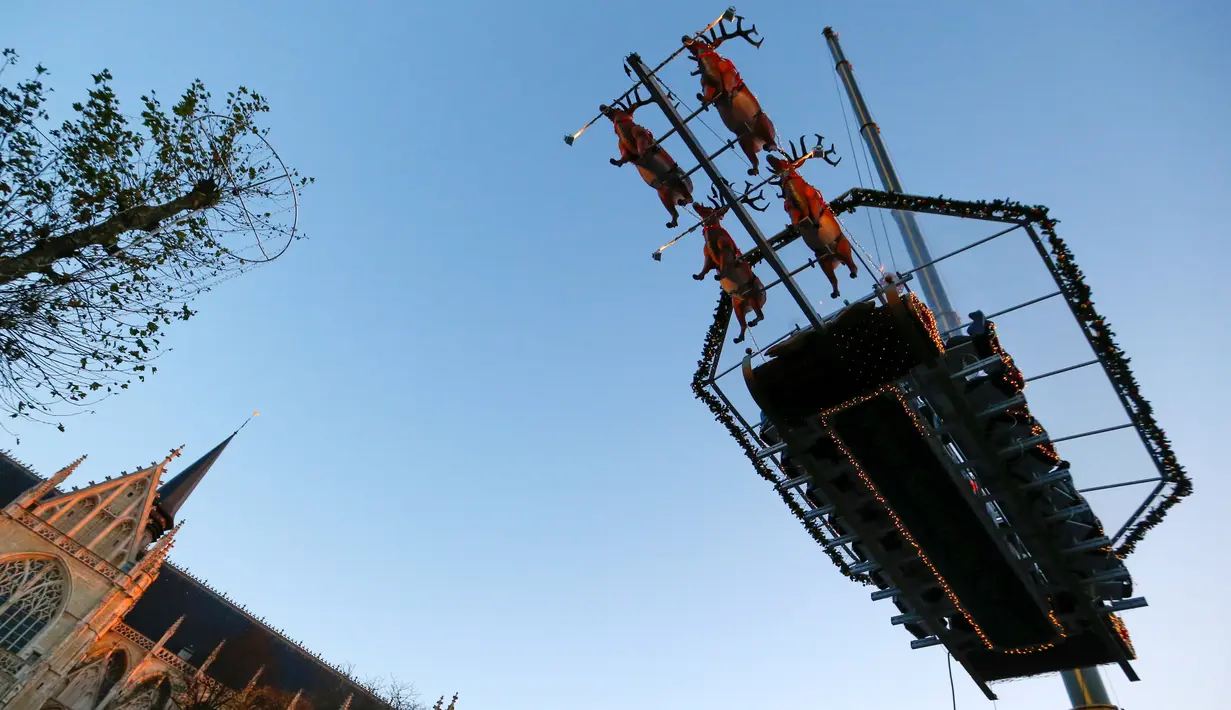 Tempat makan malam "Santa in the sky", yang diangkat dengan crane dan dihias menyerupai "Santa Sleigh" di Brussels, Belgia, 25 November 2016. Tempat makan malam ini didekorasi seperti kereta Santa Claus menjelang perayaan Natal. (REUTERS/Yves Herman)