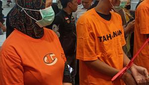 Pasutri berinisial SK (24) dan SM (39) saat mengenakan baju tahanan. (Liputan6.com/ Fauzan)