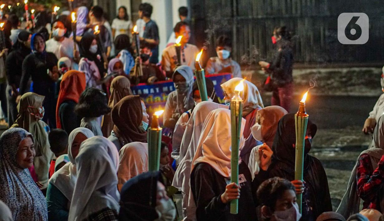 Warga mengikuti pawai obor menyambut Ramadan di kawasan Matraman Dalam, Jakarta, Minggu (27/3/2022). Pawai obor tersebut juga digelar untuk meningkatkan silaturahmi dan ukhuwah sesama umat Muslim serta menyemarakkan syiar Islam di Ibu Kota. (Liputan6.com/Faizal Fanani)
