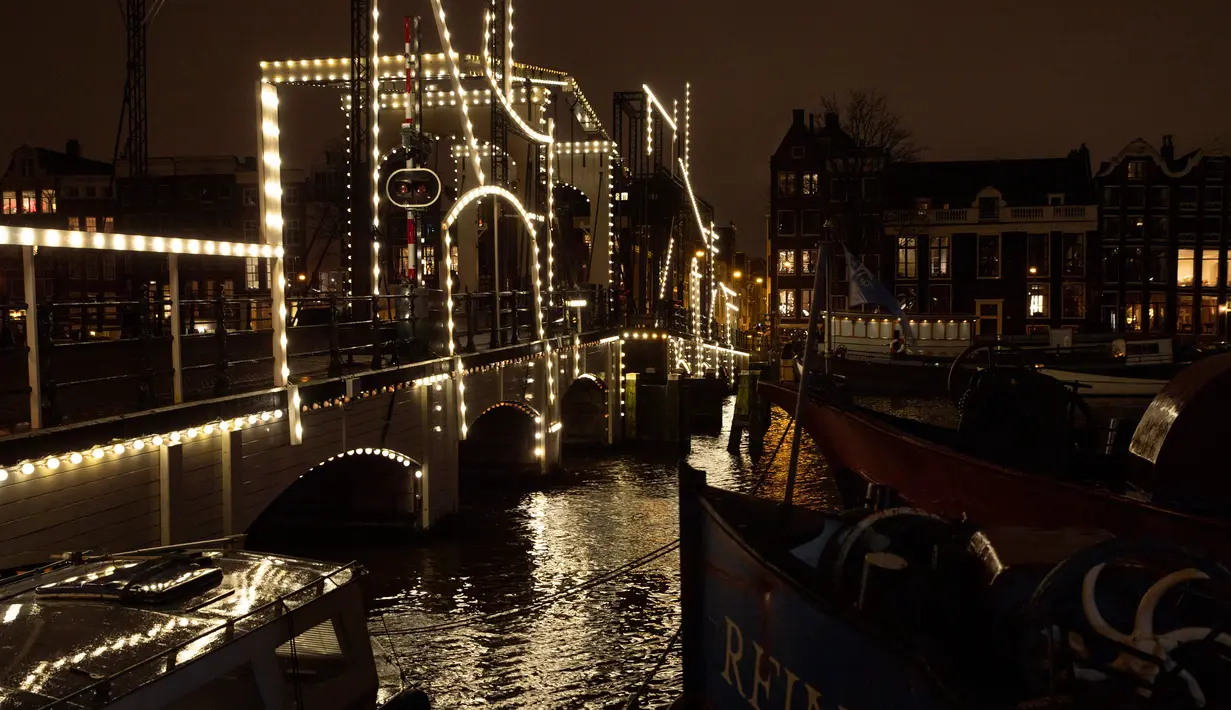 Karya seni berjudul "Nacht Tekening" atau Night Drawing oleh Krijn de Koning menghiasi Jembatan Skinny Amsterdam selama Amsterdam Light Festival di ibu kota Belanda, 27 November 2019. Festival dengan tema "DISRUPT!" ini digelar mulai 28 November hingga 19 Januari 2020 mendatang. (AP/Peter Dejong)
