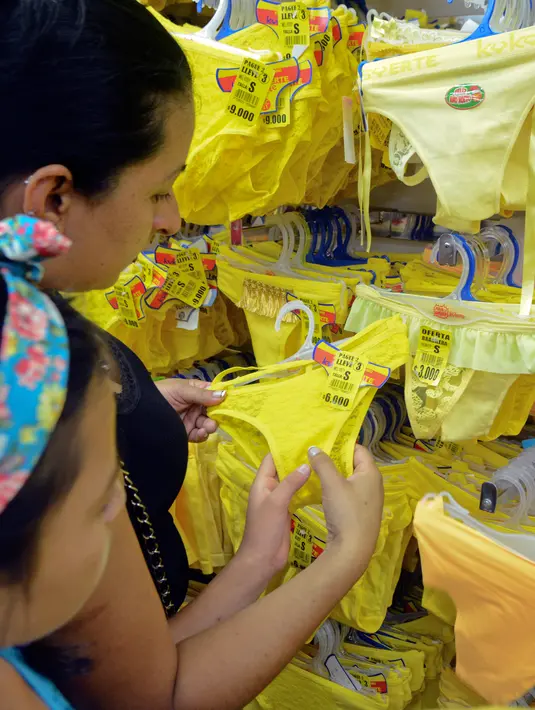 Pengunjung memilih pakaian dalam berwarna kuning yang dijual di sebuah toko di Medellin, Kolombia, Kamis (29/12). Sejumlah warga Kolombia berburu pakaian dalam berwarna kuning untuk dipakai saat perayaan tahun baru. (AFP PHOTO/Camilo GIL)