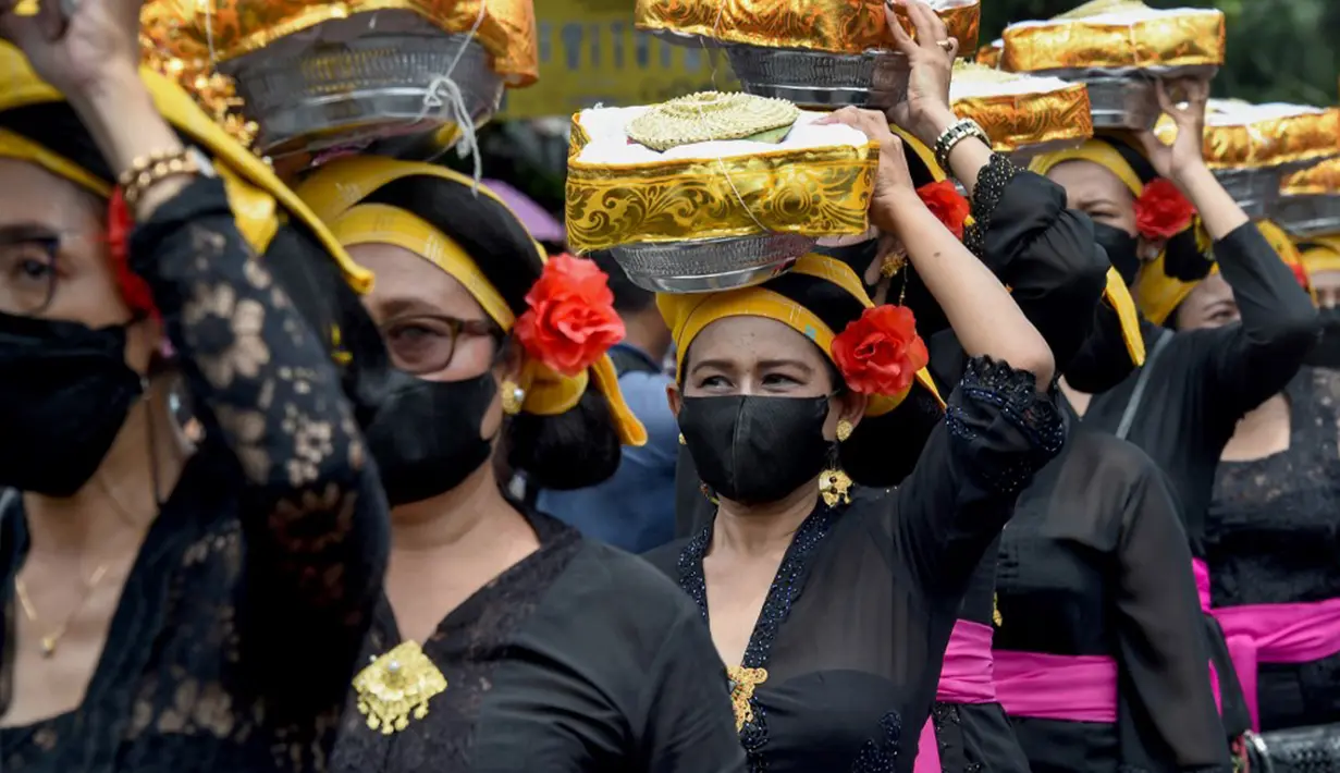 Para wanita membawa sesaji saat upacara ngaben untuk mendiang Raja Ida Cokorda Pemecutan XI atau Anak Agung Ngurah Manik Parasara di Denpasar, Bali, 21 Januari 2022. Anak Agung Ngurah Manik Parasara meninggal pada Desember lalu di usia 76 tahun. (SONY TUMBELAKA/AFP)