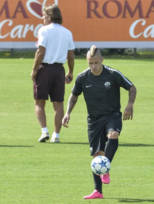 Gelandang AS Roma, Radja Nainggolan (kiri) mengontrol bola saat sesi latihan di Trigoria, Roma, Italia (15/9/2015). AS Roma akan menantang Barcelona di leg pertama penyisihan Grup E Liga Champions. (AFP PHOTO/ANDREAS Solaro)